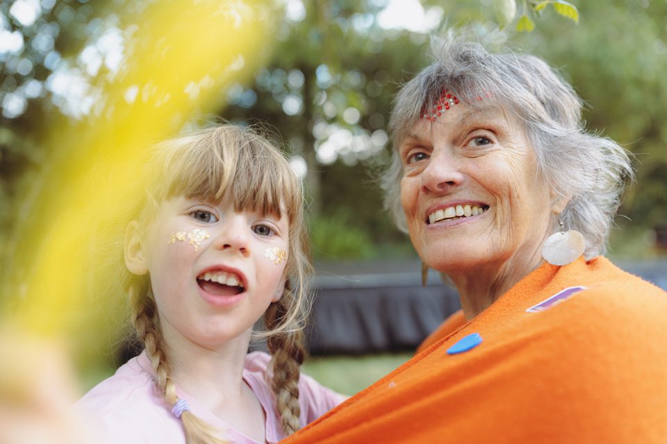 Two individuals, one child and one adult, outdoors in natural light.