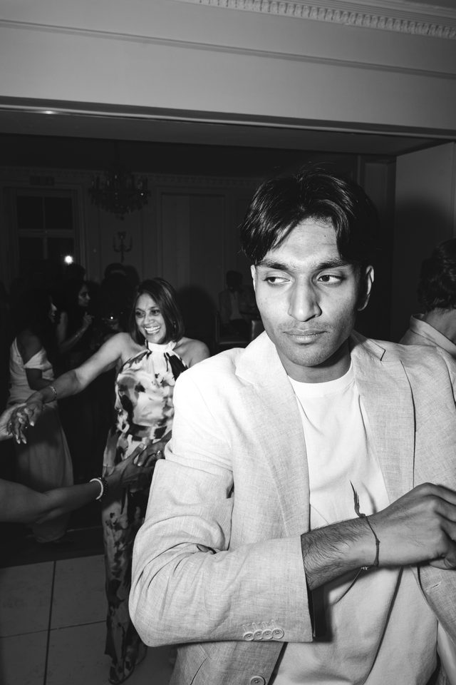 Person in light jacket dancing, others in background.